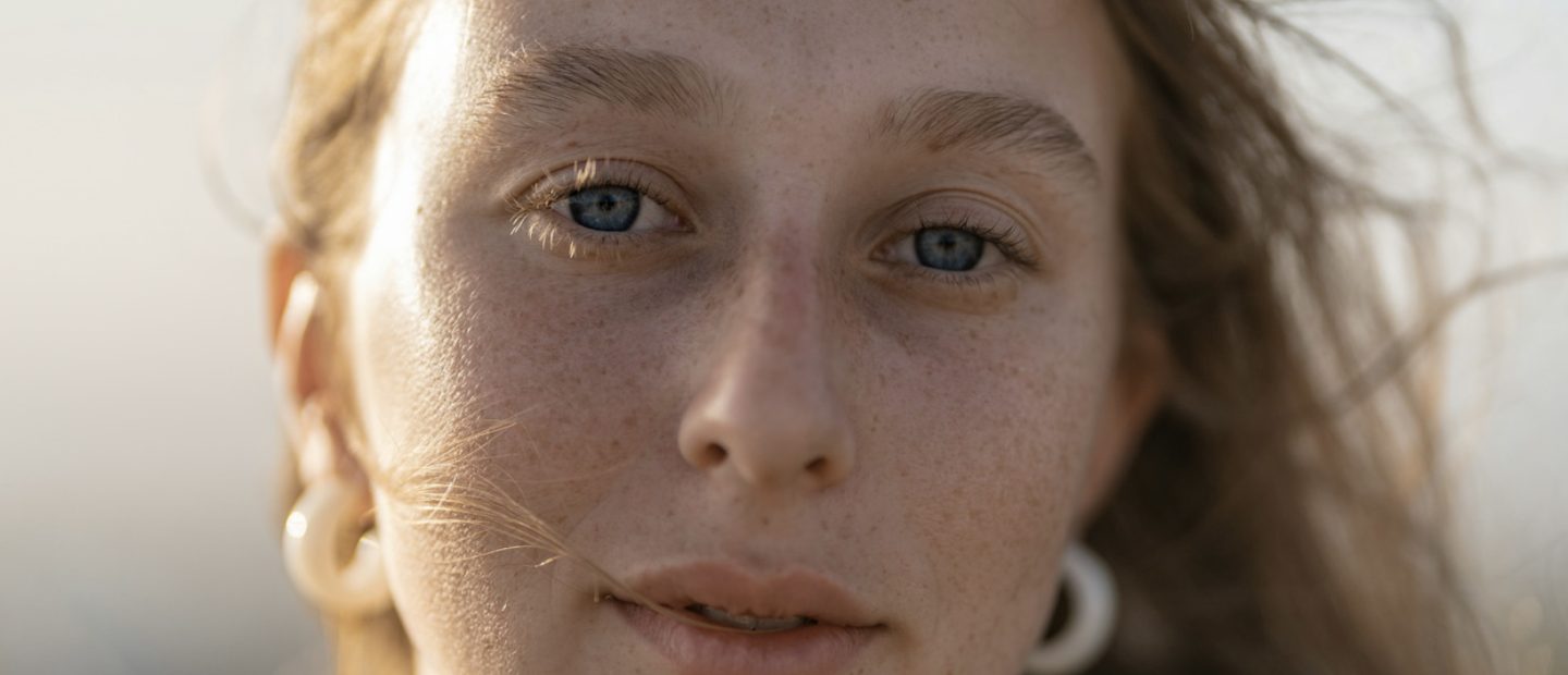 Natürliche Haut mit Sommersprossen im warmen Licht